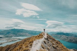 person reaching the peak of a mountain